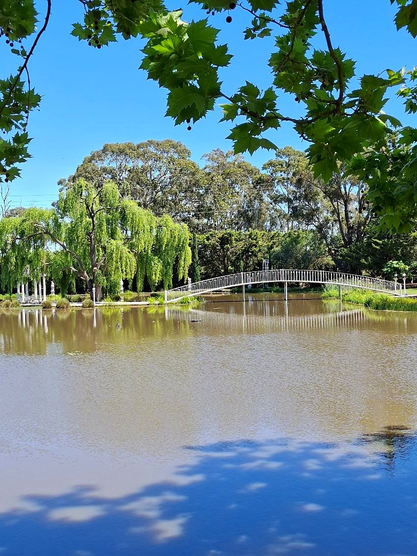 White arched footbridge across the lake
